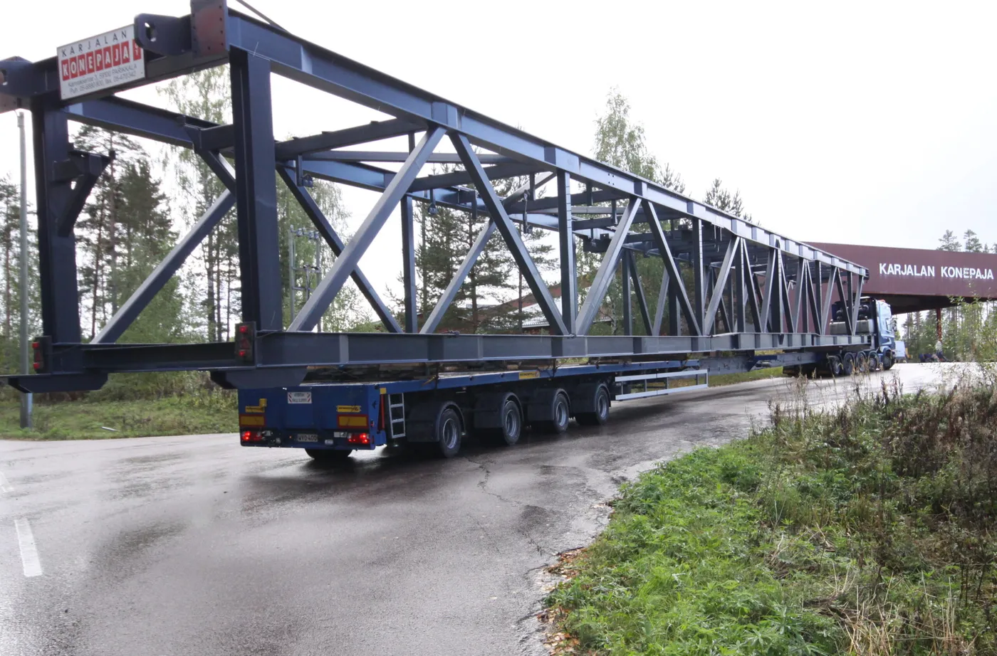 Pitkä sininen ristikkosilta jatkolavetilla lähdössä Karjalan Konepajan hallilta